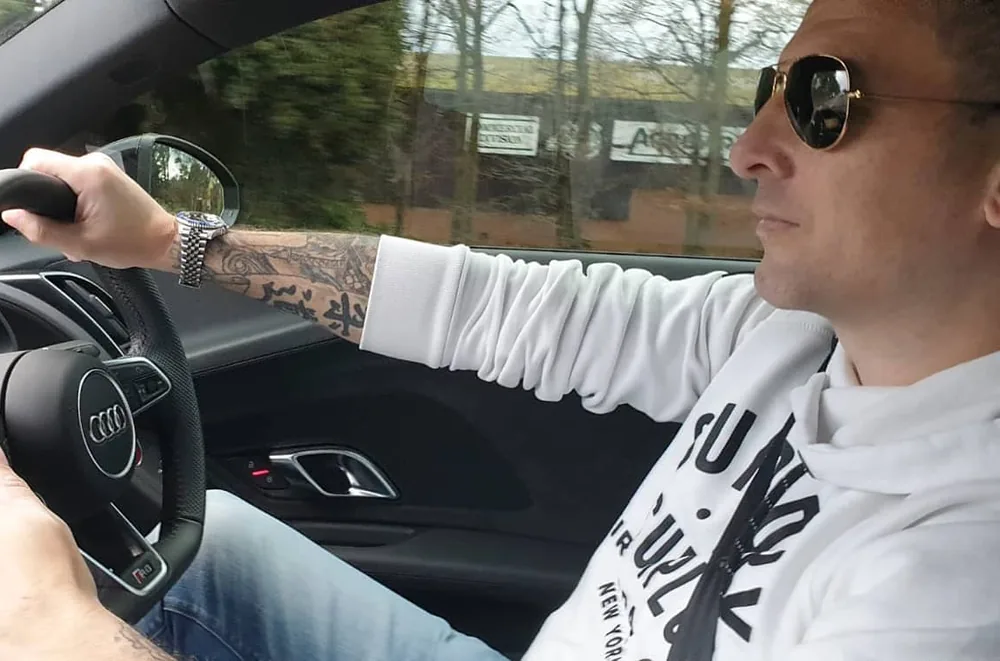 Neil Bartholomew at the wheel, hands on the steering wheel